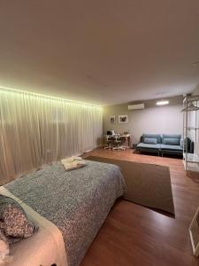 1 dormitorio con cama y sofá en GROW- Casa Parque da Cidade, en Oporto