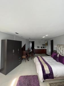 a bedroom with a large bed and a dining room at Blouberg by the Sea in Cape Town