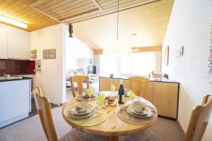 a kitchen and dining room with a wooden table and chairs at Feriensiedlung Trü 8 in Scuol