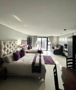 a large bedroom with two beds and a couch at Blouberg by the Sea in Cape Town