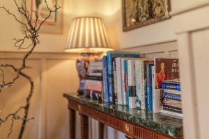 a table with a bunch of books on it at Artisan Hall: 4BD Stunning Grandeur in Cotswolds in Toddington