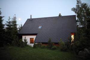 ein kleines weißes Haus mit schwarzem Dach in der Unterkunft Chata Béďa in Bedřichov