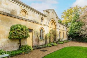 an old stone building with a garden in front of it at Artisan Hall: 4BD Stunning Grandeur in Cotswolds in Toddington