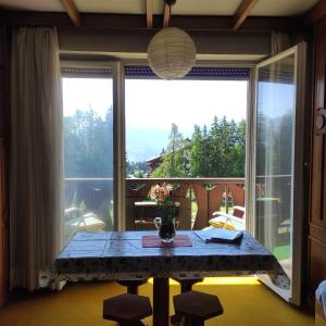 a dining room with a table and a large window at Bellevue Crans-Montana in Crans-Montana