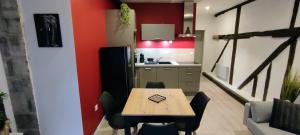 a kitchen with a table and a kitchen with red walls at 202 Duplex à colombage en plein centre ville in Bourges