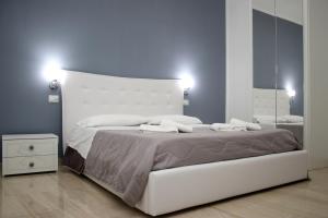 een slaapkamer met een groot wit bed en een grote spiegel bij B&B Villa Anna in Paestum