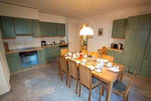 una cucina con tavolo in legno e una sala da pranzo di Villa Hartenfels 1 a Scuol