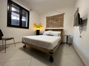 - une chambre avec un lit et une télévision dans l'établissement Appartamento con giardino a 5 min dal Mare - Burlamacco House, à Viareggio