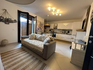 Il comprend un salon avec un canapé et une cuisine. dans l'établissement Appartamento con giardino a 5 min dal Mare - Burlamacco House, à Viareggio