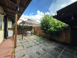 une arrière-cour avec une clôture en bois, une table et une table dans l'établissement Appartamento con giardino a 5 min dal Mare - Burlamacco House, à Viareggio