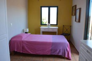 ein Schlafzimmer mit einem rosa Bett und einem Fenster in der Unterkunft en corazón centro Histórico, in Morelia + 3 Fotos