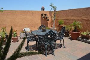 eine Terrasse mit einem Tisch, Stühlen und Topfpflanzen in der Unterkunft en corazón centro Histórico, in Morelia