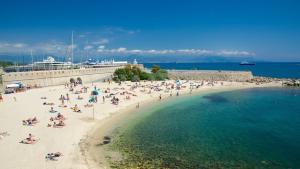 un grupo de personas en una playa con un crucero en Freshly tastefully renovated apartments in heart of old Antibes en Antibes