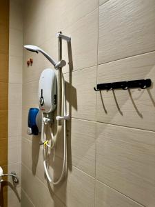 a shower in a bathroom with a hair dryer on a wall at Swing & Pillows @ Muntri in George Town