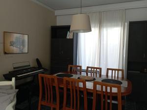 a dining room with a table and chairs and a piano at ΤΟ ΔΙΑΜΕΡΙΣΜΑ ΤΗΣ ΜΑΙΡΗΣ or MARY'S APARTMENT in Paradeísion