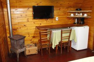 eine Küche mit einem Tisch, einem Herd und einem TV in der Unterkunft Recanto da Mata Pousada in São Francisco de Paula