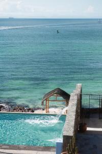 a swimming pool with the ocean in the background at Orchid House Baja in La Paz