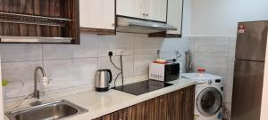a small kitchen with a sink and a microwave at The Robertson Kuala Lumpur by PremierHome 5-6pax in Kuala Lumpur