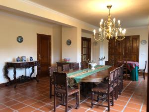 comedor con mesa, sillas y lámpara de araña en Casa das Eiras, en Tondela