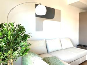 ein Wohnzimmer mit einem weißen Sofa und einer Lampe in der Unterkunft Dúplex con terraza by Prestigi in Terrassa