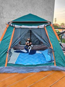 ein Zelt mit einem Mädchen, das auf einem Bett liegt in der Unterkunft Smilingface guesthouse in Sukhothai