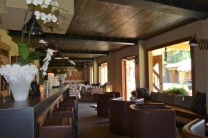 a restaurant with a bar with chairs and tables at La Tresenda Hotel and Mountain Farm in Livigno