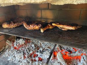 three pieces of meat cooking on a grill at Casa Arena Authentique maison de village avec piscine au cœur de l’Alta Rocca - Zoza in Zoza