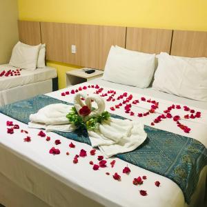 um quarto com duas camas com flores vermelhas em Hotel Pousada Latitude em Canoa Quebrada