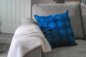 a blue and white pillow sitting on a couch at Greenside Getaway in Newarthill