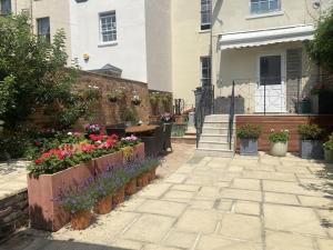 a garden in front of a house with flowers at Clarence House: 4BD Georgian Townhouse in Cheltenham