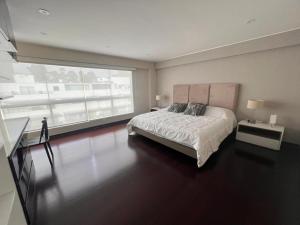 1 dormitorio con cama y ventana grande en El Golf los inkas luxury Penthouse, en Lima
