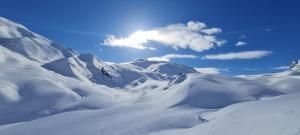 a snow covered mountain with the sun in the sky at FERIENWOHNUNGEN TANJA - dein Wohlfühlhaus in Kappl in Kappl