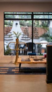 uma sala de estar com uma mesa e uma grande janela em Hostal Casa Mosaiko Patio Bonito Poblado em Medellín
