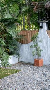 uma cerca branca com uma planta à frente em Hostal Casa Mosaiko Patio Bonito Poblado em Medellín