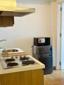 a kitchen with a stove and a microwave at Azure Staycation Near the Airport in Manila