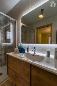 een badkamer met een wastafel en een grote spiegel bij A l'oree des monts in Bassens