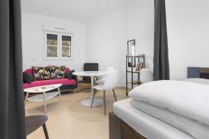 Un dormitorio con una cama, un sofá y una mesa. en Studio 2 proche centre avec parking, en Fréjus