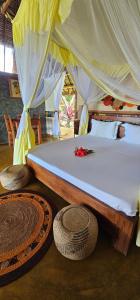 a bed in a room with baskets on the floor at KINTANA LODGE in Ile aux Nattes