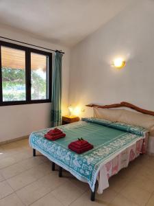 een slaapkamer met een bed met groene lakens en een raam bij B&B i Bonsai Talana in Ardali