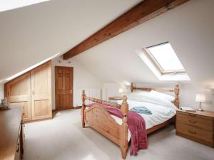 a bedroom with a wooden bed and a skylight at 3 bed property in Wigton 83471 in Aikton