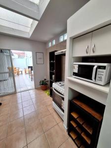 una cocina con estufa y microondas en LIPA HOUSE Mendoza., en Mendoza