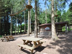 two wooden picnic tables in front of a cabin at 2 Bed in Lydbrook 83665 in Lydbrook