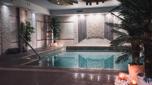 ein Schwimmbad in einem Haus mit einer Pflanze in der Unterkunft Eliton Hotel & Spa in Kato Loutraki