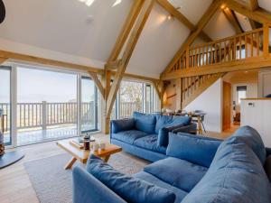 una sala de estar con sofás azules y techo de madera. en 1 bed in Taunton 86623, en Broomfield
