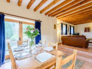 a dining room with a wooden table and a couch at 3 Bed in Bettws Cedewain 86785 in Bettws Cedewain