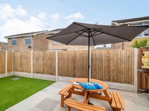 a patio with an umbrella and a table at 2 Bed in Caister-on-Sea 87689 in Caister-on-Sea