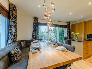 a dining room with a wooden table with wine glasses at 4 Bed in East Cowes 87819 in Newport