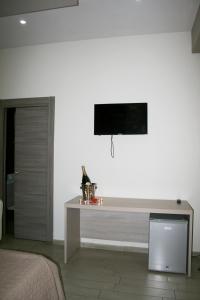 una camera con un letto e una televisione a parete di Angel's Paradise a Mariglianella