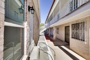 eine leere Gasse zwischen zwei Gebäuden mit einer Bank in der Unterkunft El Paso Vacation Rental about 6 Mi to Downtown! in El Paso