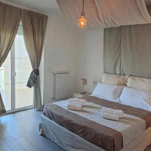 a bedroom with a large bed with two towels on it at B&B AIRPORT BARI DELUXE28 in Bari